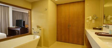 A modern bathroom with a bathtub, vanity, and a large mirror.
