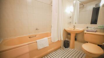 A bathroom with a bathtub, sink, toilet, and a mirror.