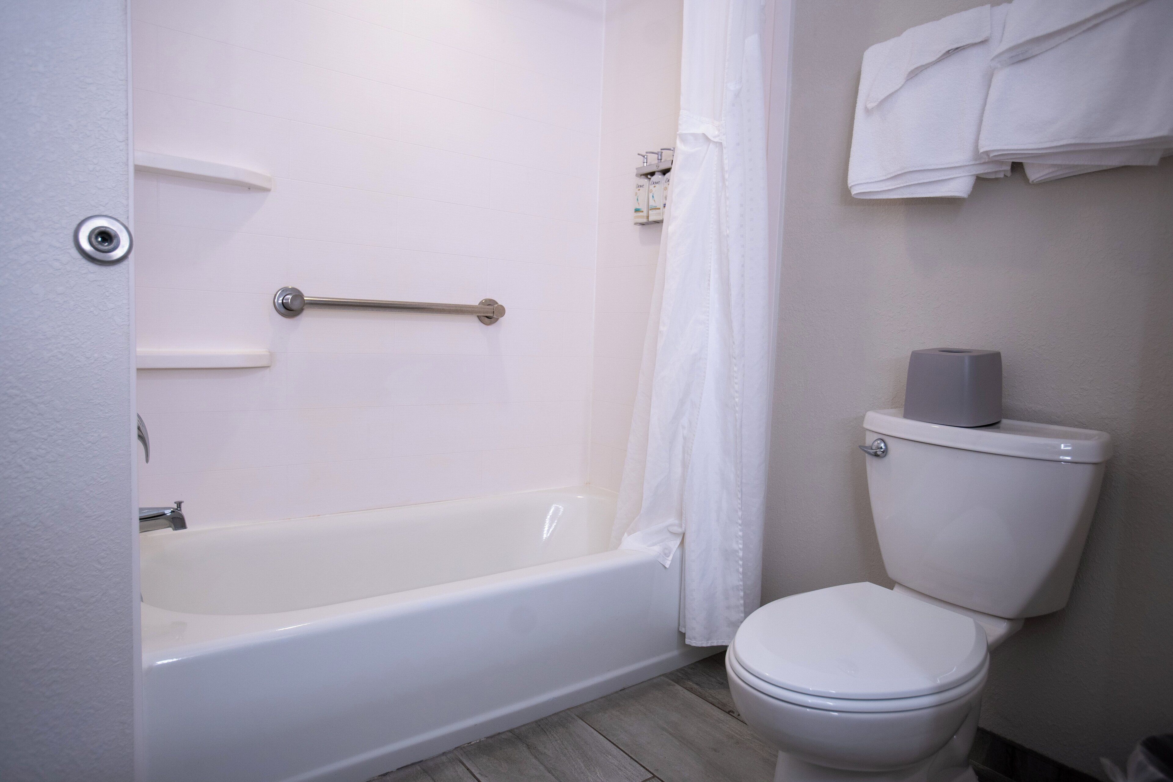 Une salle de bain avec une baignoire, des toilettes et un rideau de douche.