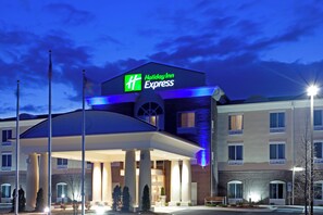 Un hotel Holiday Inn Express con un letrero llamativo, una zona de estacionamiento techada y fachada de ladrillo.