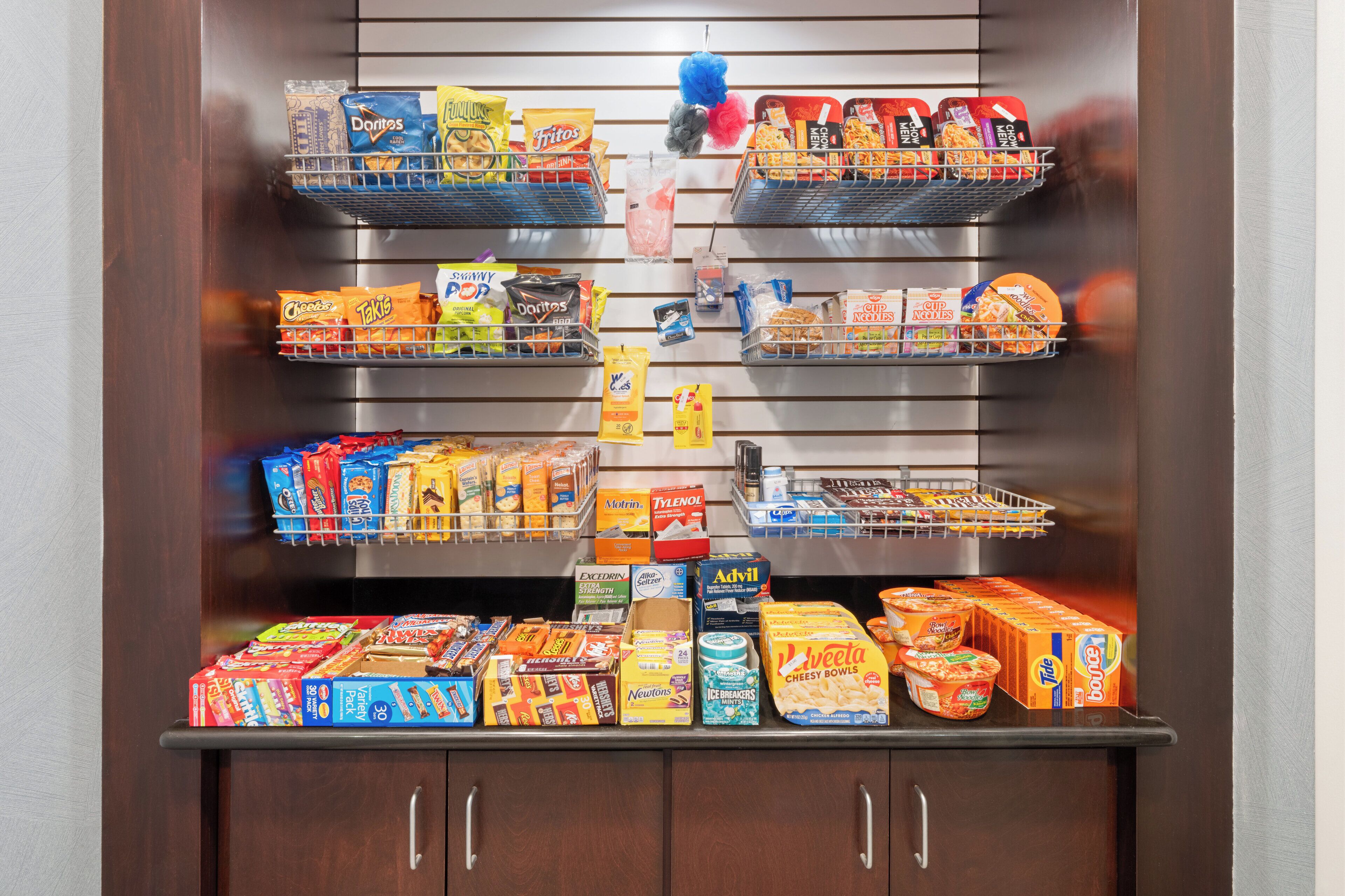 A refrigerated display case stocked with various food items including snacks, dairy products, and beverages.