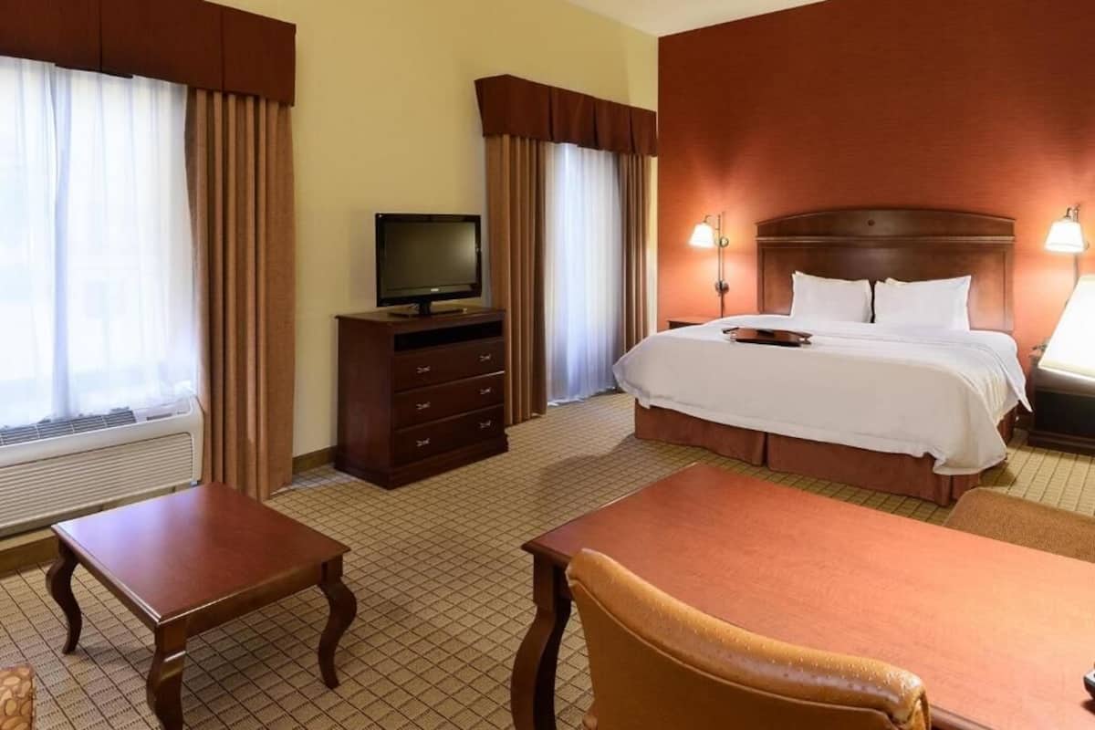 A hotel room with a bed, a television, a desk, and a chair.