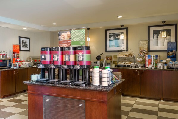 A self-service beverage station with multiple coffee dispensers and a variety of food items.