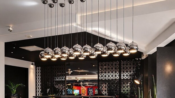 A modern lobby with a black marble floor, a reception desk, and a unique ceiling light fixture. - Bab Hotel (Marrakech)
