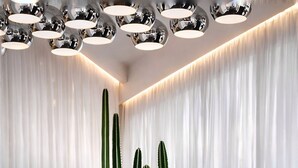 A reception area with a large white 'BAB' sign, a chandelier, and cacti in the background. - Bab Hotel (Marrakech)