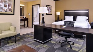 A hotel room with a bed, desk, chair, and a bathroom with a shower. - Hampton Inn & Suites Big Spring (Big Spring)