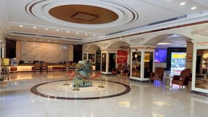 A spacious lobby with a marble floor, a central decorative fountain, and a reception desk. - Dihao Hotel (Quanzhou)