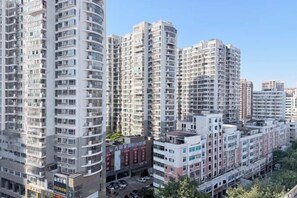 A high-rise residential building with multiple floors, balconies, and a clear sky. - Dihao Hotel (Quanzhou)