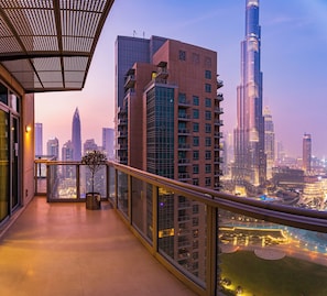 A balcony with a city view, including high-rise buildings and a river.