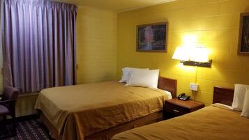A hotel room with two beds, a chair, a nightstand with a phone, and a painting on the wall.