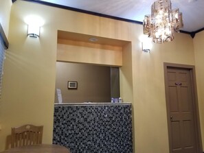 A room with a wooden chair, a small table, a mirror, a clock, and a door marked "Employee Only". - Motel 7 Rawlins (Rawlins)