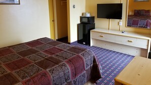 A hotel room with a bed, a TV, a desk, and a wardrobe. - Motel 7 Rawlins (Rawlins)