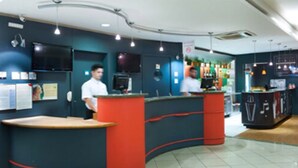 A modern reception area with curved counters and a bar area. - ibis Uberlandia (Uberlandia)