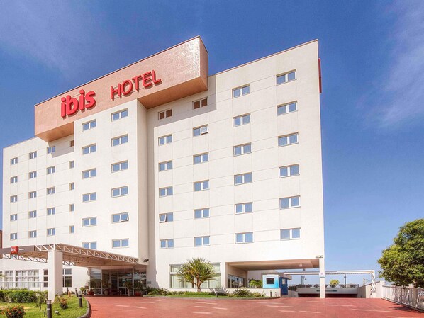 A modern hotel building with a prominent 'ibis HOTEL' sign, multiple floors, and a covered entrance area. - ibis Uberlandia (Uberlandia)