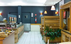 Un restaurant doté d’un comptoir, de chaises, de tables et de luminaires suspendus.