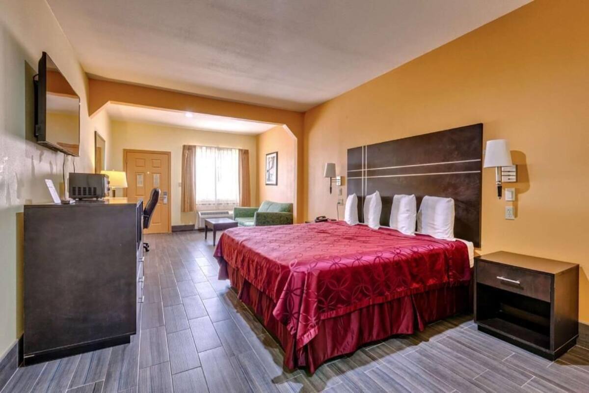 Une chambre d’hôtel équipée d’un lit, d’un bureau, d’une chaise et d’un téléviseur.