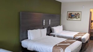A hotel room with two beds, a large dark headboard, and a framed picture on the wall. - Quality Inn Brownsville (Brownsville)