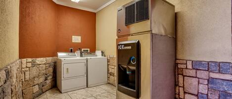 A laundry area with a washing machine, dryer, and an ice dispenser.