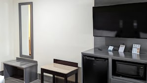 A compact kitchenette with a microwave, a small refrigerator, a sink, and a mirror. - Quality Inn Brownsville (Brownsville)