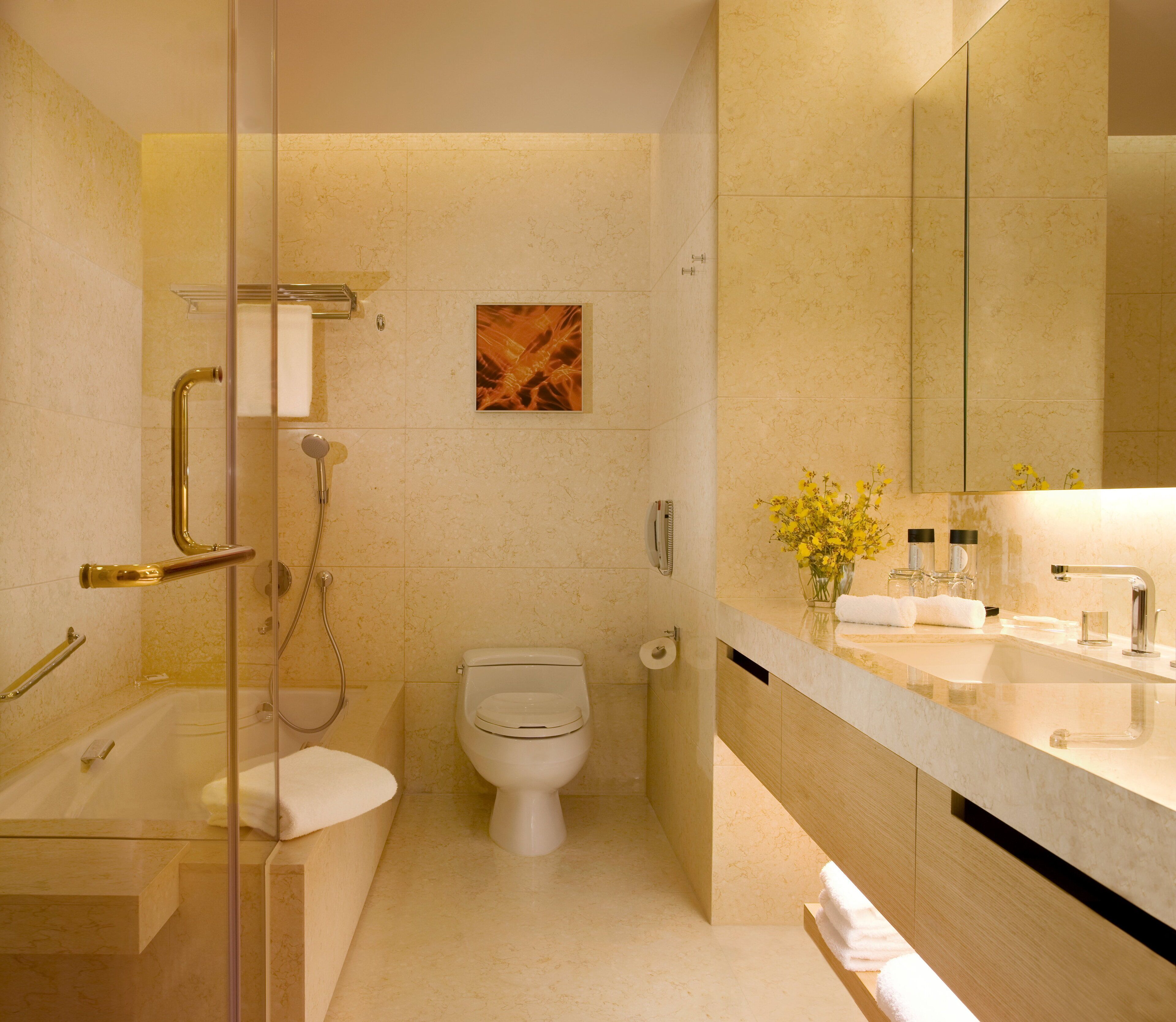 A modern bathroom with a glass-enclosed shower, a toilet, and a vanity with a mirror.