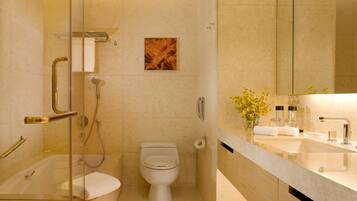 A modern bathroom with a glass-enclosed shower, a toilet, and a vanity with a mirror.
