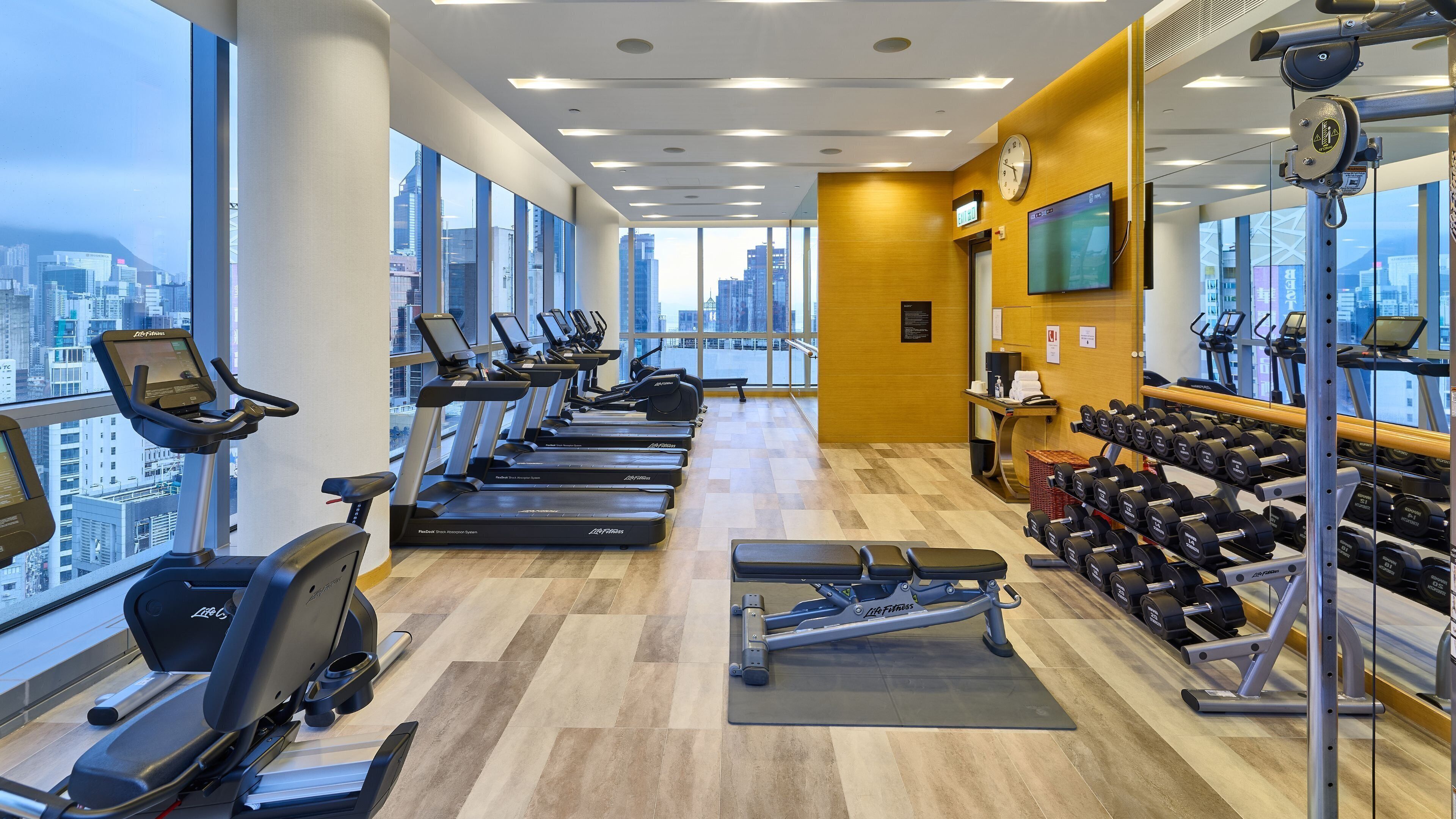 Une salle de sport équipée de tapis de course, d’haltères et d’appareils d’exercice.
