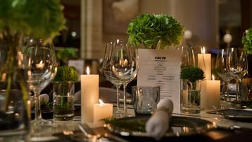A table set for a meal with a menu, candles, and decorative greenery.