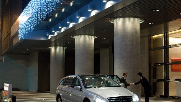 A modern building with a glass facade and a car parked in front. - Crowne Plaza Hong Kong Causeway Bay by IHG (Hong Kong)