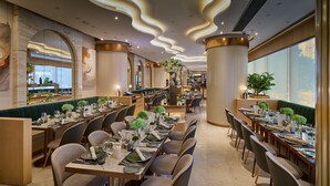 A restaurant with long communal tables, high ceilings with wavy lighting, and large windows. - Crowne Plaza Hong Kong Causeway Bay by IHG (Hong Kong)