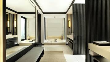 A modern bathroom with a large mirror, a bathtub, and a vanity with a sink.