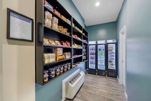 A grocery store with shelves stocked with various food items and two refrigerated display cases.