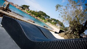 Un área de descanso en la playa con vista al mar y al paisaje rocoso.