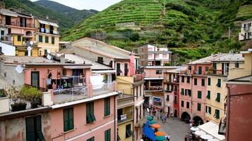 Un borgo collinare con vigneti a terrazza, edifici colorati e aree salotto all'aperto.