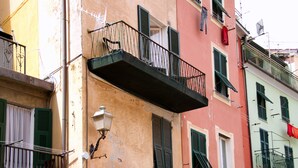 A multi-story building with balconies, a visible window with shutters, and a small outdoor area with potted plants. - Rollando Affittacamere (Vernazza)