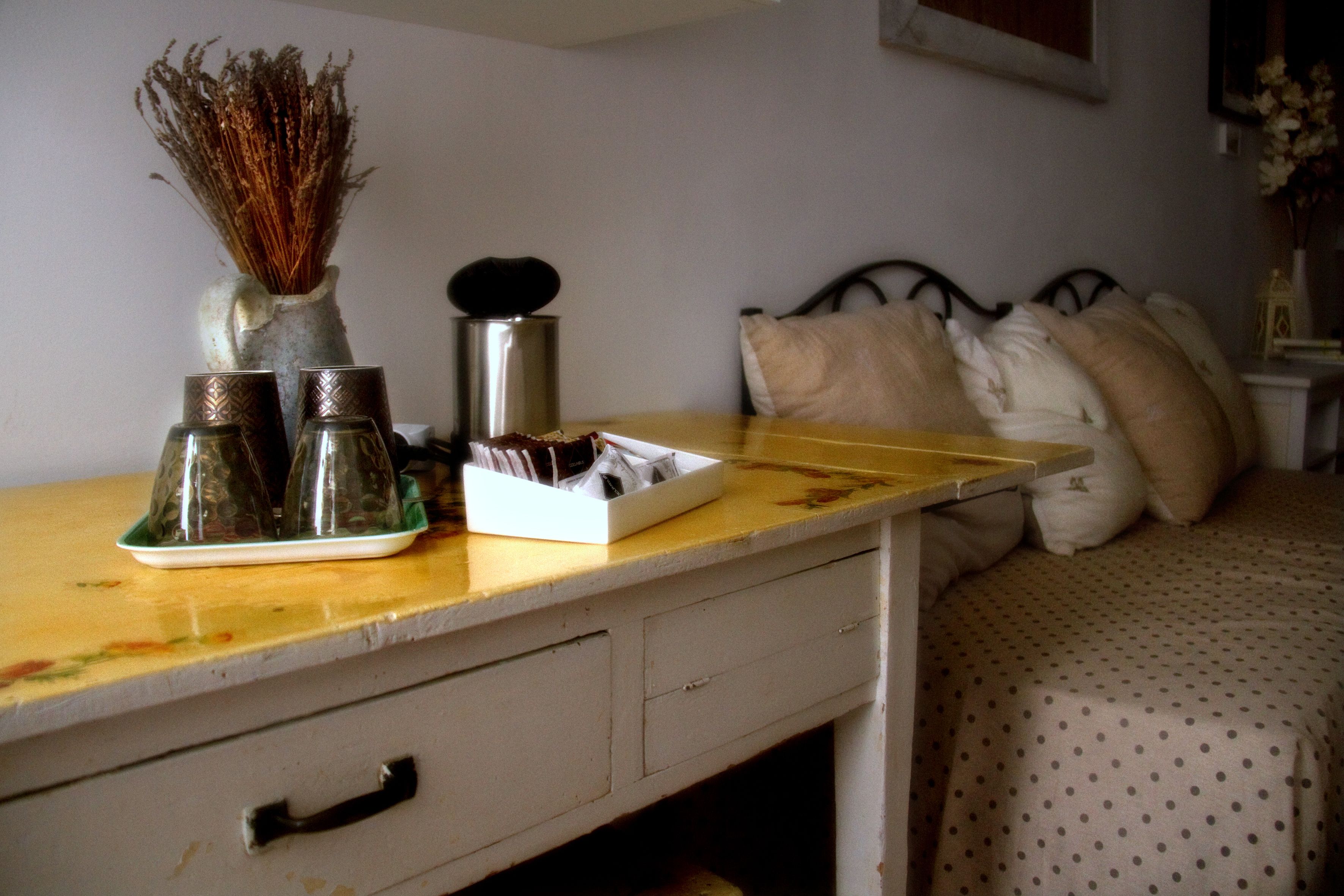 Une chambre à coucher avec un lit, des oreillers, une table de chevet et une commode.