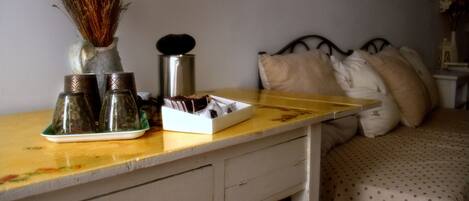 Une chambre à coucher avec un lit, des oreillers, une table de chevet et une commode.