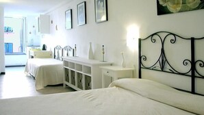 A hotel room with two beds, a white dresser, and a large window. - Rollando Affittacamere (Vernazza)