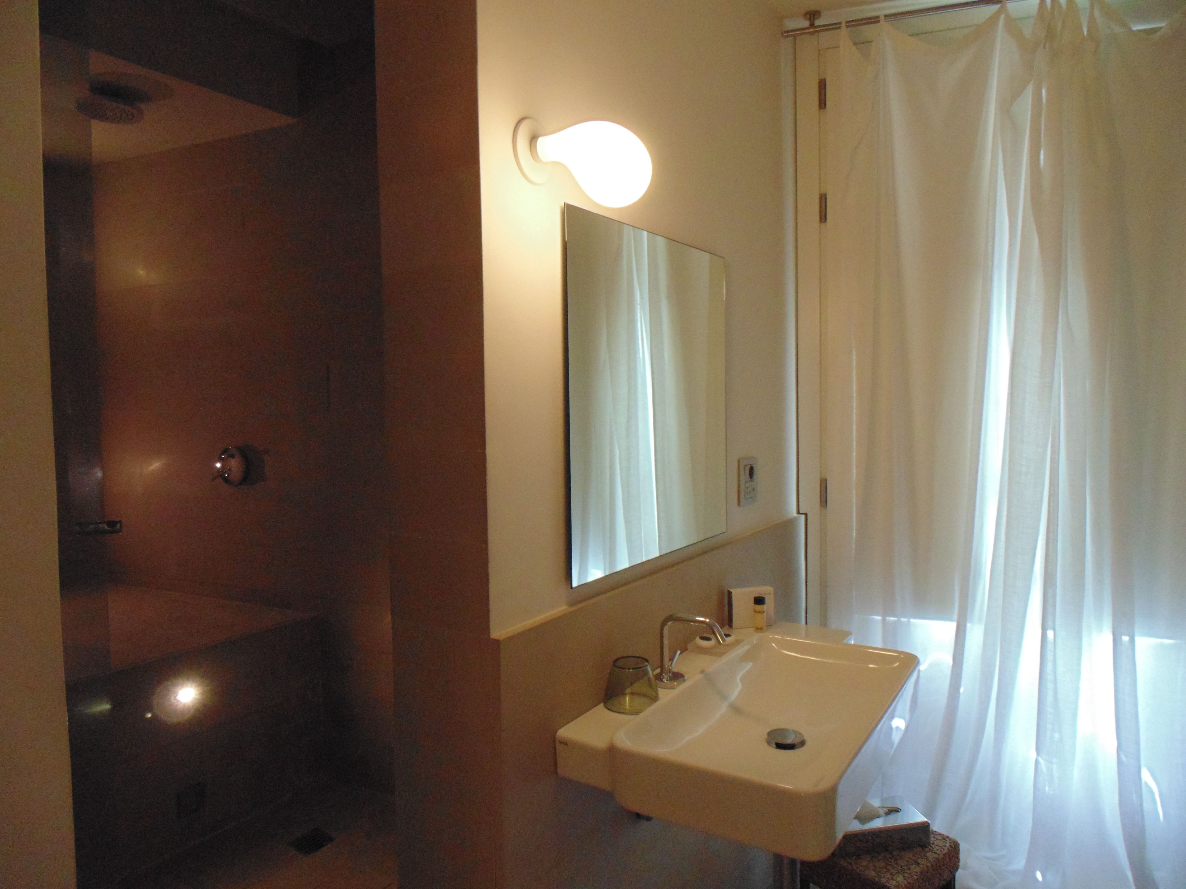 Ein Badezimmer mit Waschbecken, Spiegel und Duschvorhang.