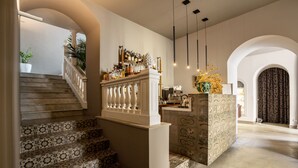 Un escalier orné de carreaux décoratifs, un coin bar avec des bouteilles et un vase décoratif.