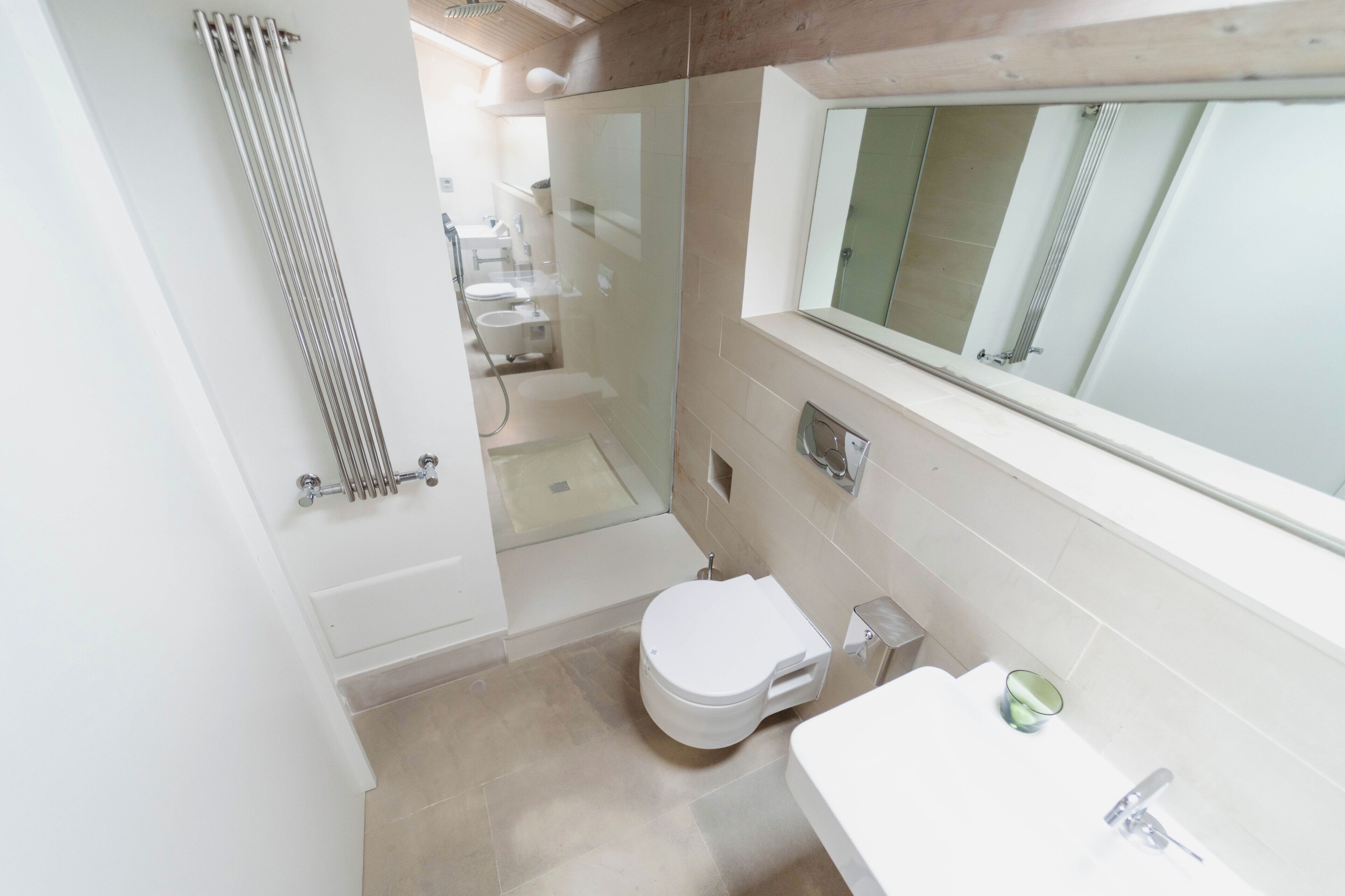 A compact bathroom with a toilet, sink, and shower.