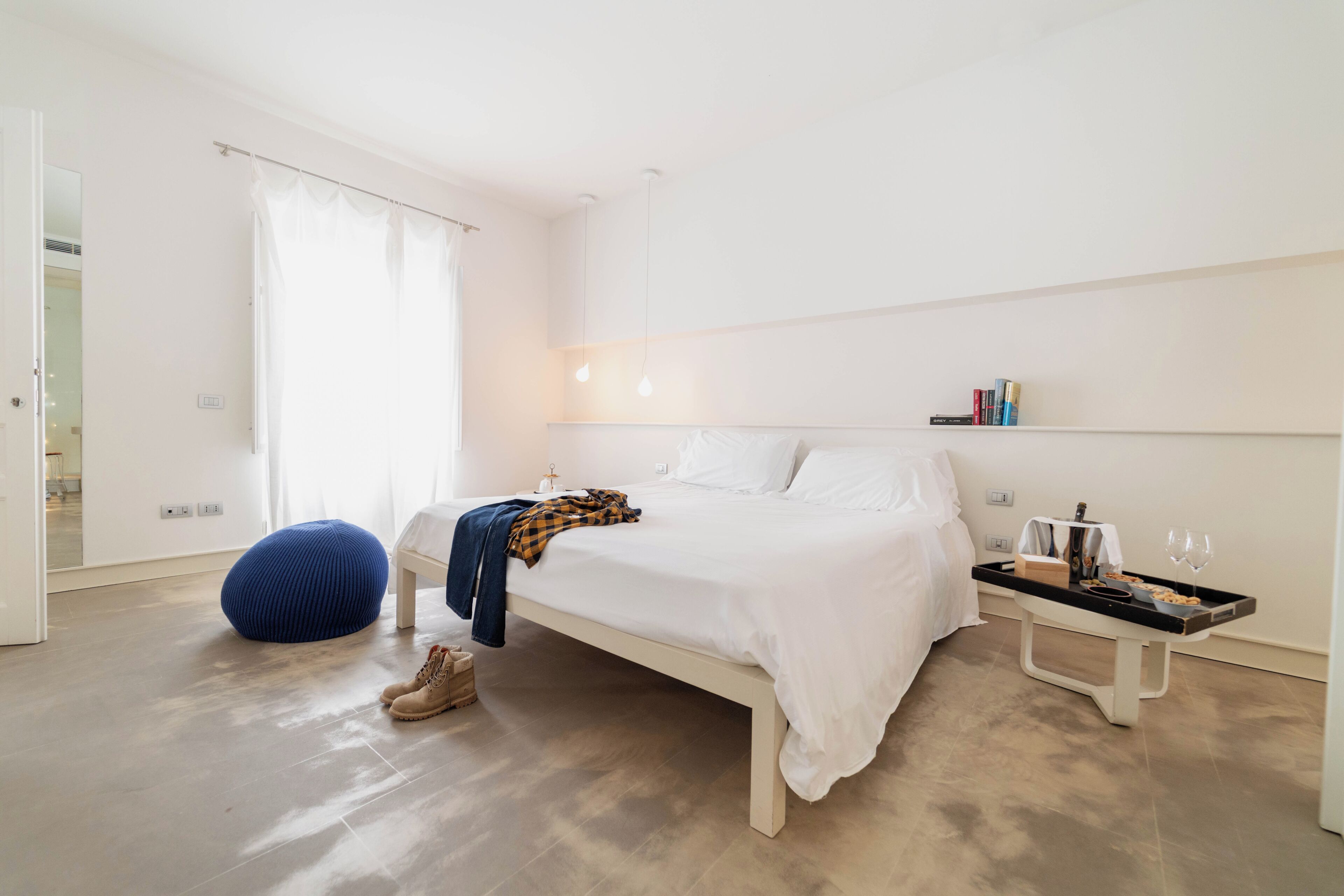 A bedroom with a bed, bedside table, and a chair.