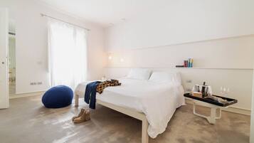 A bedroom with a bed, bedside table, and a chair.