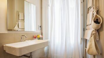 A bathroom with a white sink, a mirror, and a shower curtain.