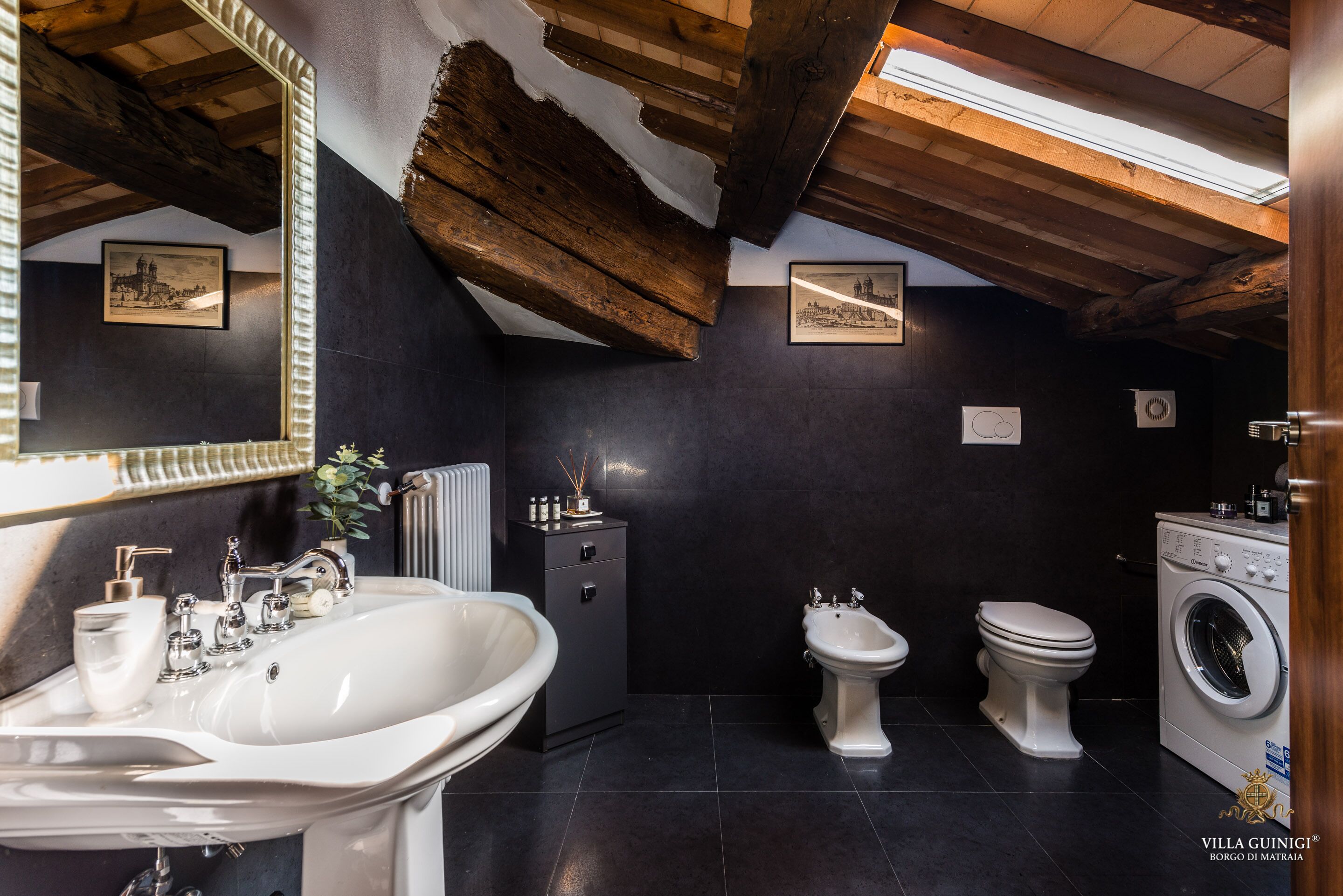 Een badkamer met een wastafel, bidet, toilet en wasmachine.