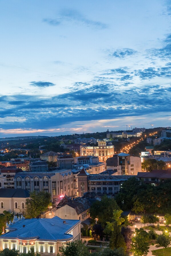 A cityscape with historic buildings, a prominent church, and a well-lit street at dusk.