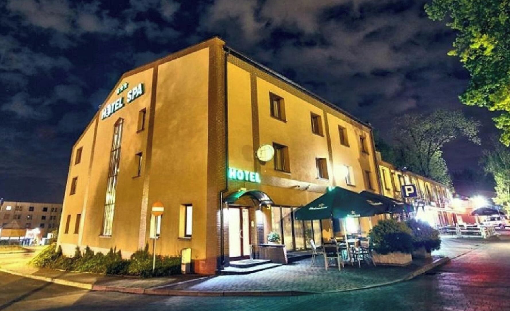 A hotel with a sign indicating it is a hotel spa, outdoor seating area, and a parking sign.