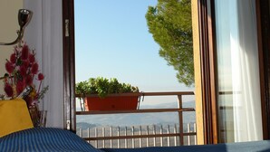 A room with a bed, a window with a view of the outdoors, a potted plant, and a curtain. - Il Castellaccio (Perugia)