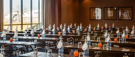 A conference room with tables set up for a meeting, each with water bottles and nameplates.