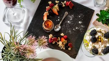 Una mesa de postres con diversas frutas, nueces y un recipiente pequeño de mermelada.