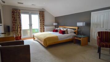 Een hotelkamer met een bed, een stoel, een bureau en een deur.